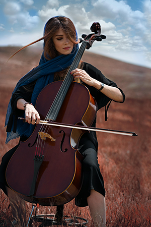 Iranian woman playing instrument in middle desert